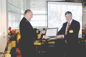 Cdre. Ruud Petterson, RNLN (l), receives a certificate of appreciation for his briefing from van der Lelie.
